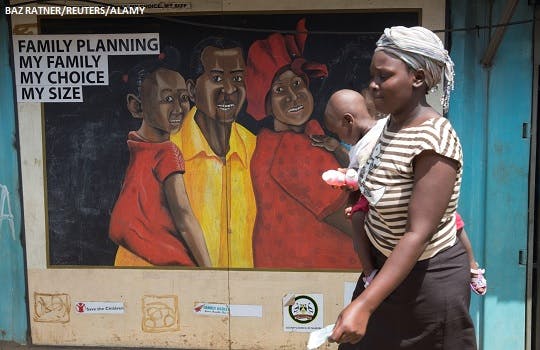 A woman walks past a mural on family planning in Nairobi, Kenya