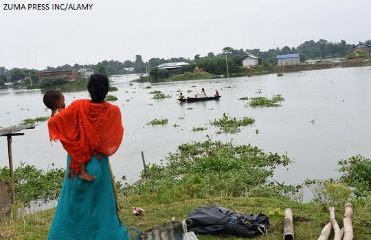 A woman looks on at floods in India
