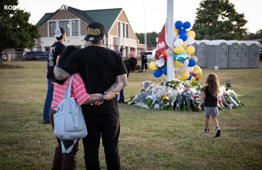Students and residents gather with flowers outside Apalachee High School on the day after a shooting spree in Winder, Georgia