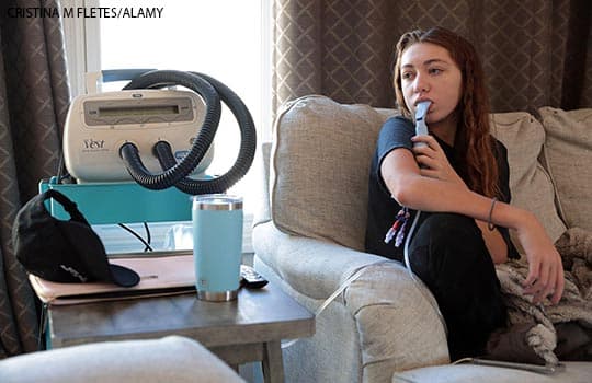 A patient with cystic fibrosis doing breathing treatments